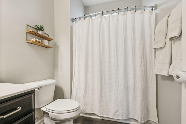bathroom featuring toilet, a shower with curtain, and wood finished floors