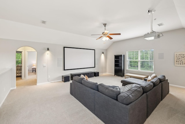 cinema with light colored carpet, vaulted ceiling, ceiling fan, and arched walkways