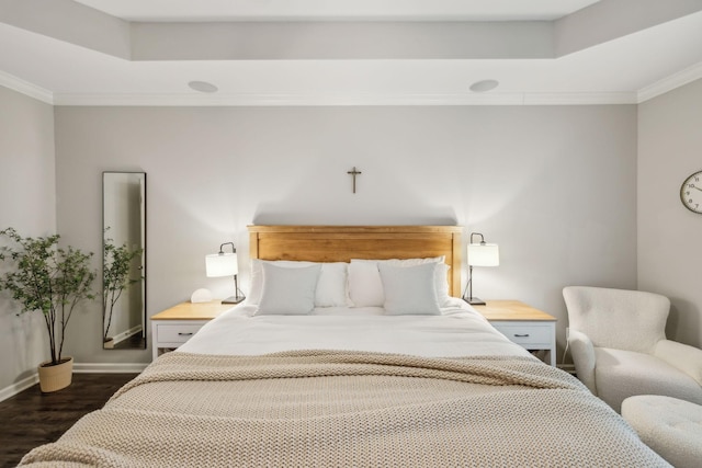 bedroom featuring crown molding, a raised ceiling, baseboards, and dark wood finished floors