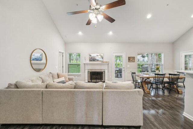 living area featuring a fireplace, dark wood-type flooring, high vaulted ceiling, and recessed lighting