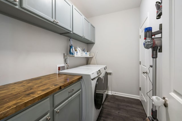 clothes washing area featuring cabinet space, independent washer and dryer, dark wood-style flooring, and baseboards