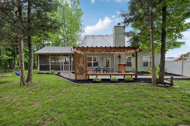 rear view of property with a chimney, a yard, fence, a pergola, and a wooden deck