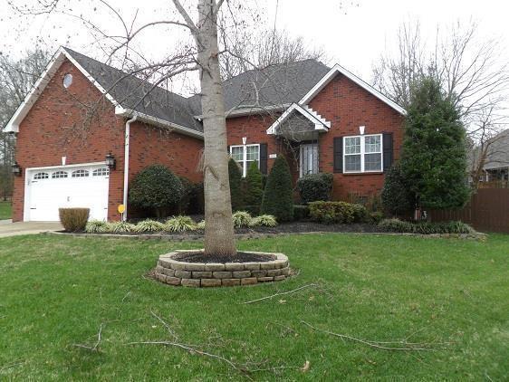 view of front of house featuring concrete driveway, a garage, a front lawn, and brick siding