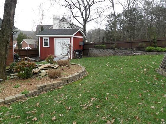 view of yard with an outbuilding, a fenced backyard, and a storage unit