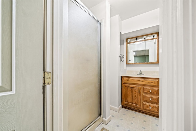 full bath with vanity, baseboards, and a stall shower