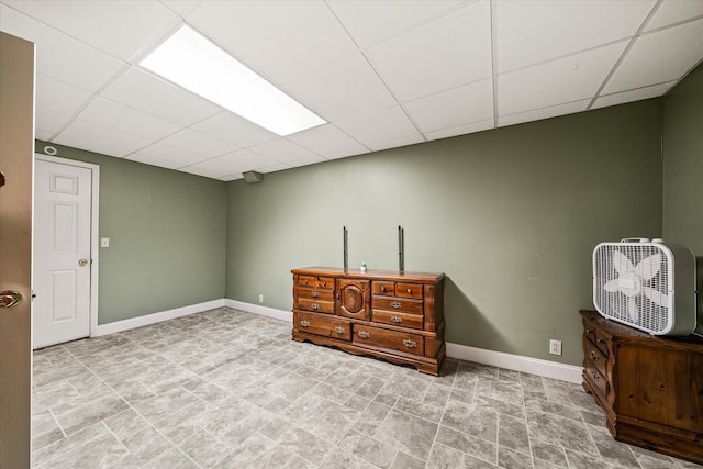 interior space with baseboards and a drop ceiling