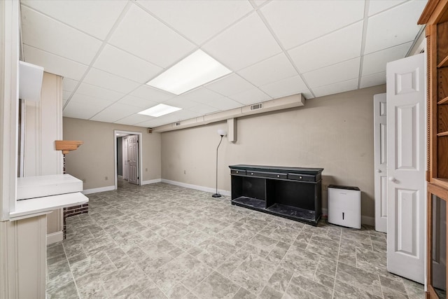 finished basement with a paneled ceiling, baseboards, and visible vents