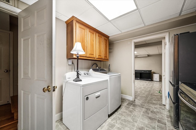 laundry area featuring washer and clothes dryer, cabinet space, and baseboards