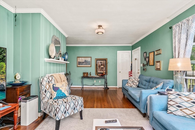 living area with baseboards, crown molding, and wood finished floors