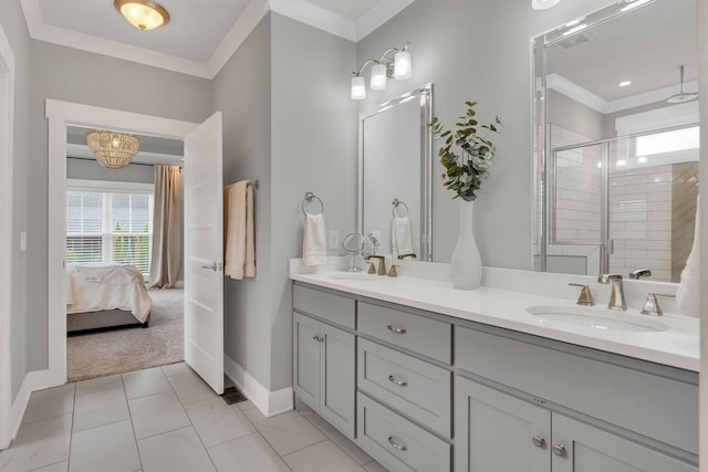 ensuite bathroom featuring a sink, crown molding, a stall shower, and baseboards