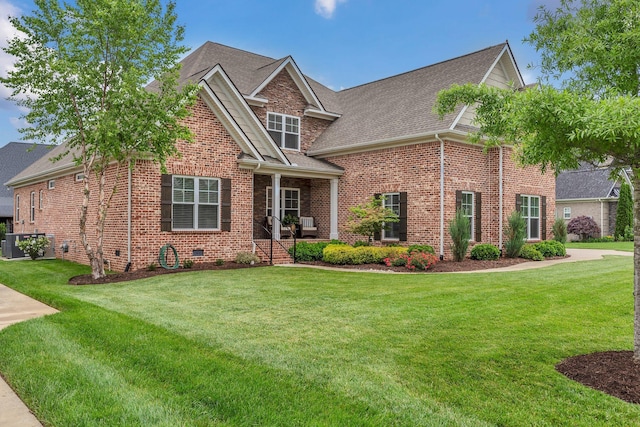 craftsman inspired home featuring central AC, a shingled roof, brick siding, and a front yard