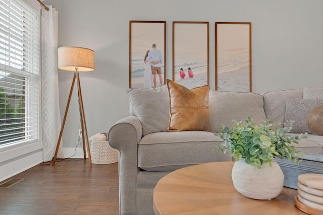 living room with visible vents, wood finished floors, and baseboards