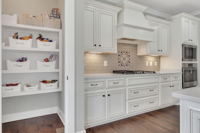 kitchen featuring premium range hood, stainless steel appliances, dark wood-style flooring, backsplash, and white cabinetry