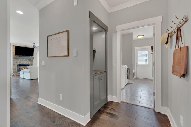 corridor featuring washing machine and clothes dryer, dark wood-type flooring, baseboards, and recessed lighting