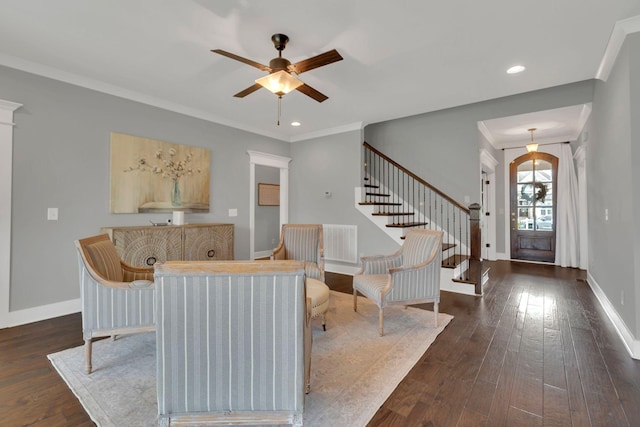 living room featuring a ceiling fan, hardwood / wood-style floors, visible vents, baseboards, and stairs