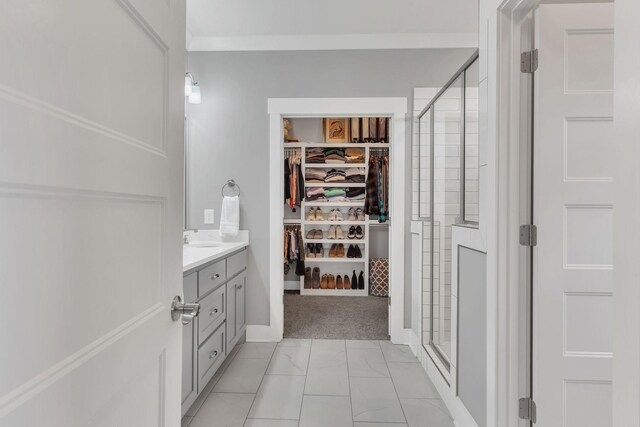 full bath featuring vanity, marble finish floor, a shower stall, and a spacious closet
