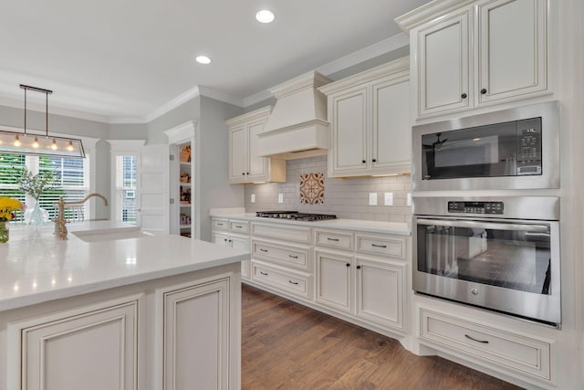 kitchen with stainless steel oven, built in microwave, a sink, light countertops, and custom exhaust hood