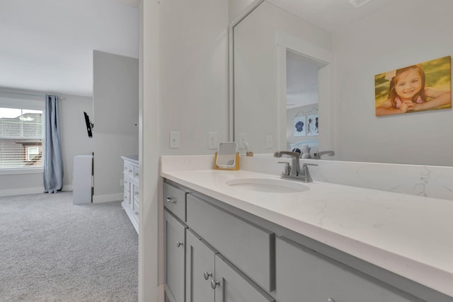 bathroom featuring vanity, ensuite bathroom, and baseboards