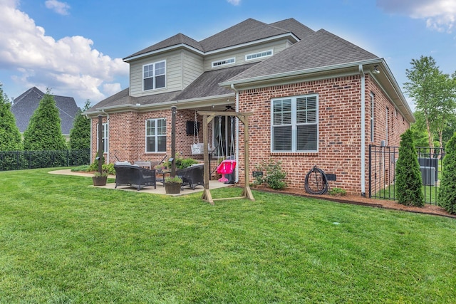 view of front of property featuring a front lawn, brick siding, ceiling fan, and fence