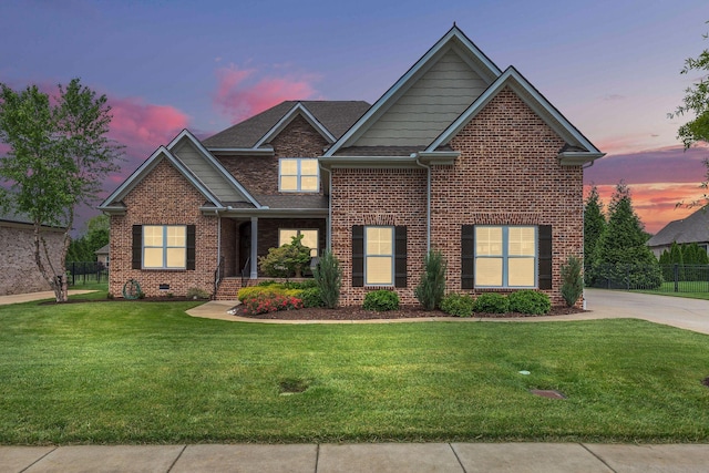 craftsman house with a front yard, brick siding, and fence