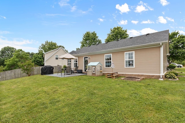 back of property with a lawn, a patio area, and fence