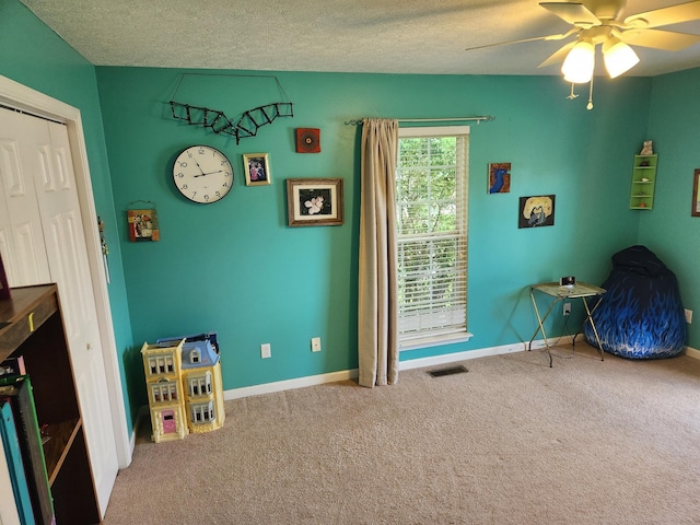 recreation room featuring visible vents, baseboards, a ceiling fan, and carpet floors