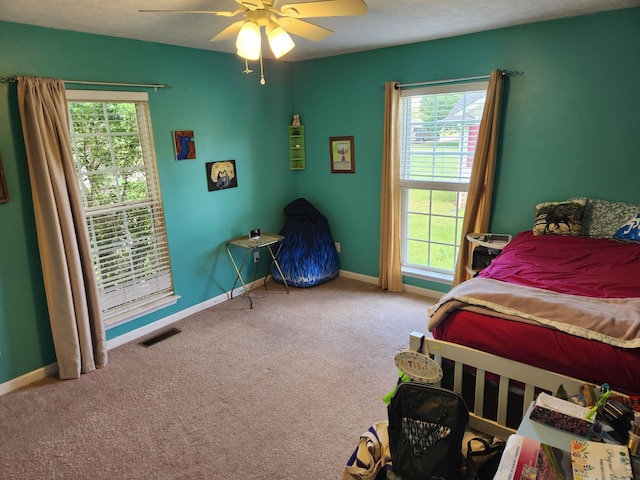 bedroom featuring carpet flooring, baseboards, visible vents, and multiple windows