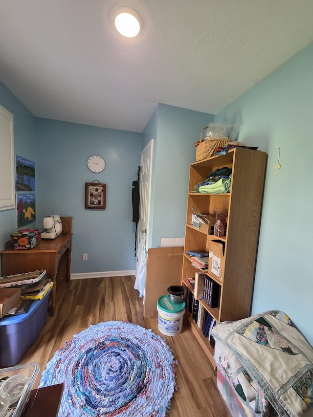 bedroom with wood finished floors and baseboards