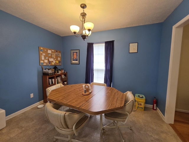 tiled dining room with a chandelier and baseboards