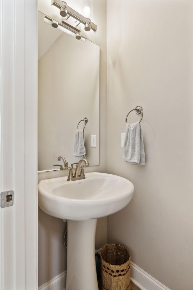 bathroom featuring baseboards and a sink