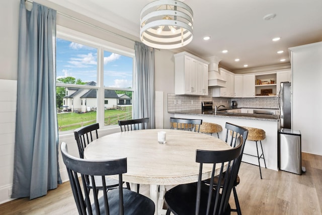 dining space featuring light wood-style flooring and recessed lighting