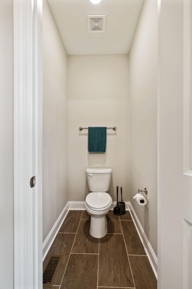 bathroom featuring tile patterned floors, toilet, visible vents, and baseboards