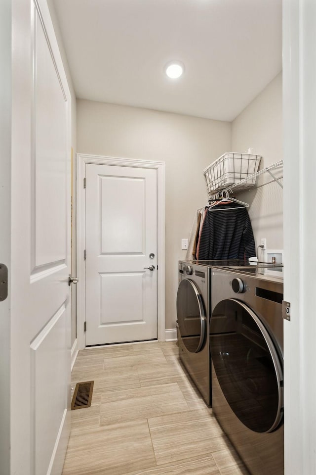 clothes washing area with washer and dryer, laundry area, visible vents, baseboards, and recessed lighting