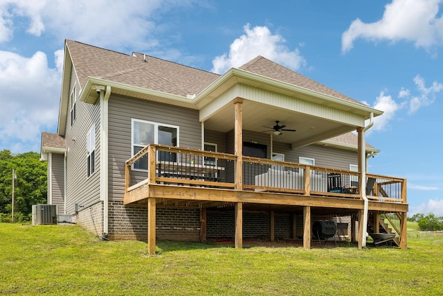 back of property featuring a ceiling fan, central AC, a deck, a lawn, and roof with shingles
