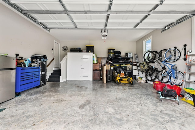 garage featuring freestanding refrigerator and a garage door opener