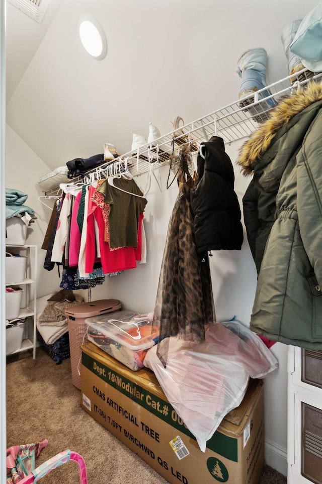 walk in closet with lofted ceiling, visible vents, and carpet floors