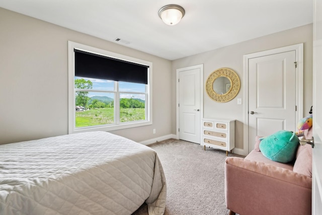 carpeted bedroom with visible vents and baseboards