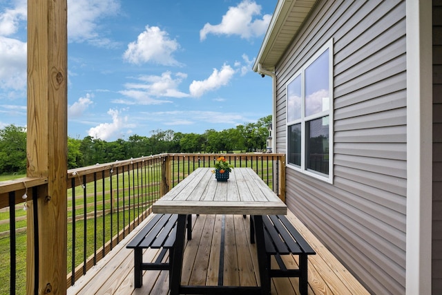 wooden terrace with a lawn and outdoor dining area