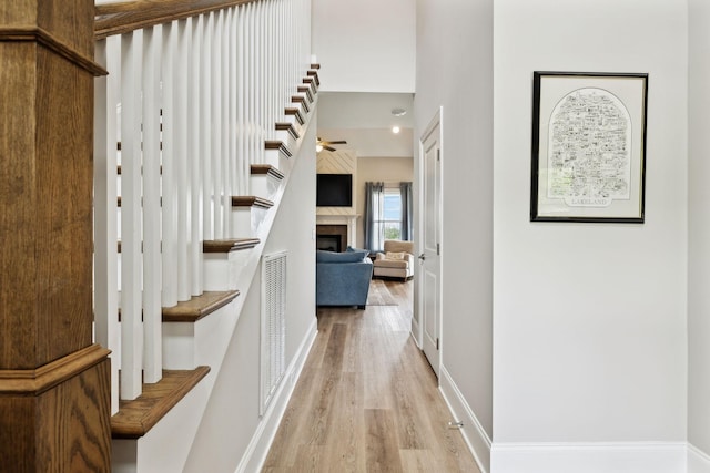 corridor featuring visible vents, wood finished floors, and baseboards