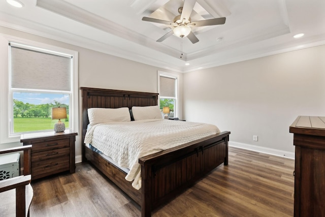 bedroom featuring a tray ceiling, dark wood-style floors, ornamental molding, and recessed lighting