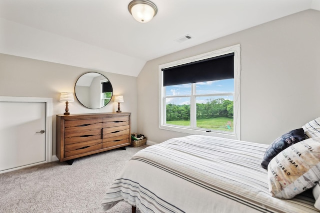 carpeted bedroom featuring vaulted ceiling, baseboards, and visible vents