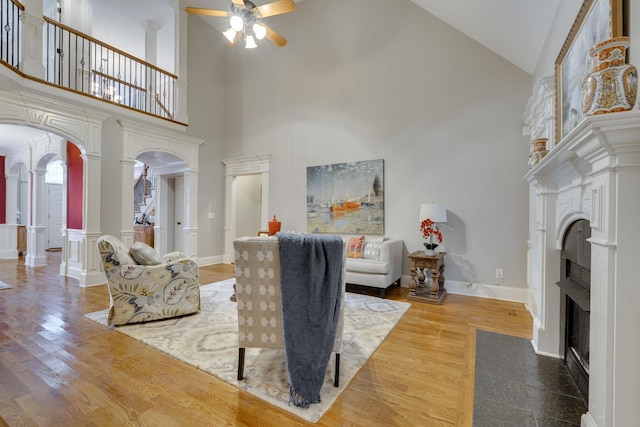 2808 Wynthrope Hall Dr N, Murfreesboro, TN 37129 - living area featuring a ceiling fan, decorative columns, a fireplace with flush hearth, arched walkways, and a high ceiling