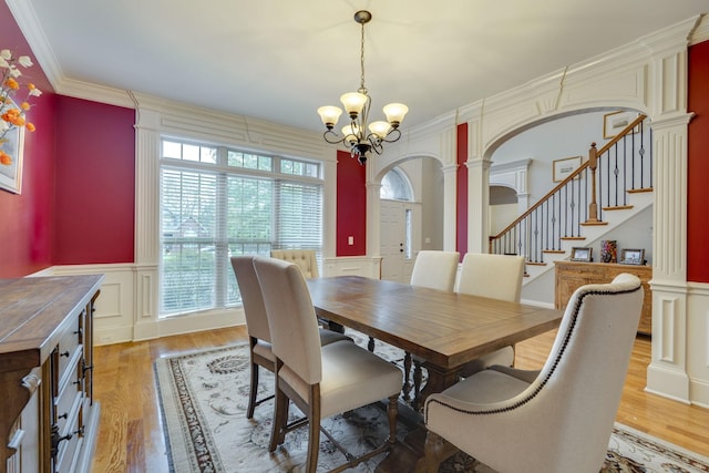 2808 Wynthrope Hall Dr N, Murfreesboro, TN 37129 - dining room with wainscoting, a decorative wall, a chandelier, arched walkways, and ornate columns