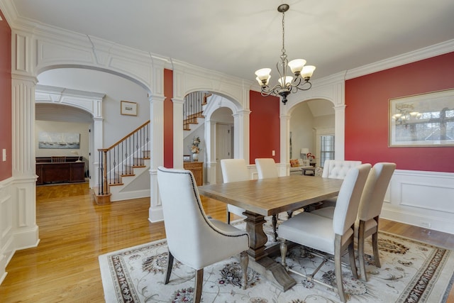 2808 Wynthrope Hall Dr N, Murfreesboro, TN 37129 - dining area featuring ornate columns, stairway, a chandelier, arched walkways, and light wood-style floors