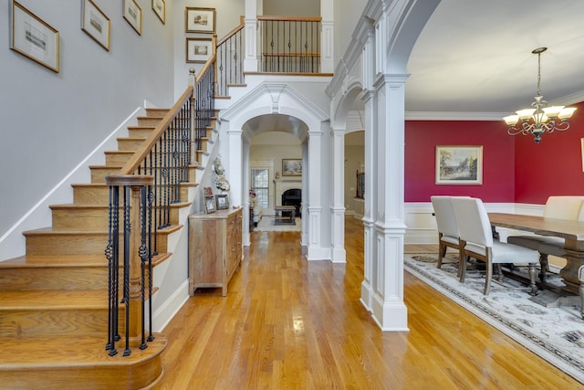 2808 Wynthrope Hall Dr N, Murfreesboro, TN 37129 - foyer entrance featuring stairway, light wood finished floors, a fireplace, arched walkways, and a notable chandelier