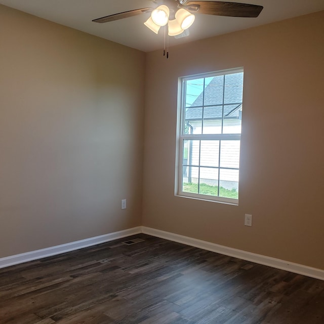 spare room with a wealth of natural light, baseboards, ceiling fan, and dark wood-style floors