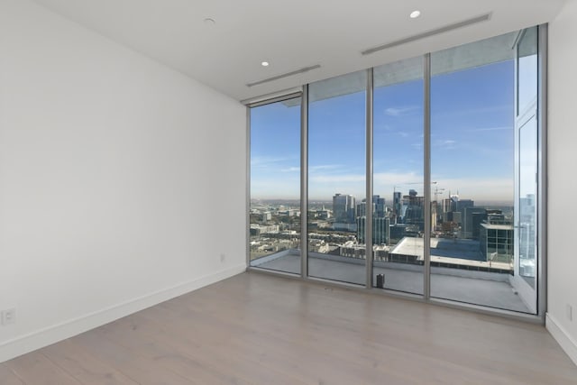 1616 W End Ave Unit 3202, Nashville, TN 37203 - spare room featuring expansive windows, a city view, baseboards, and wood finished floors
