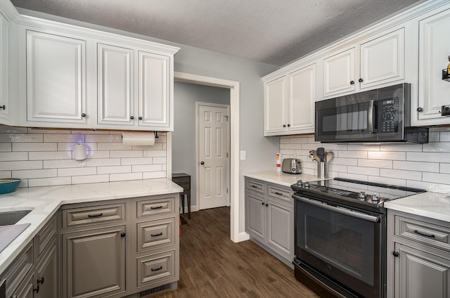 kitchen with white cabinets, dark wood-type flooring, black appliances, backsplash, and light stone counters
