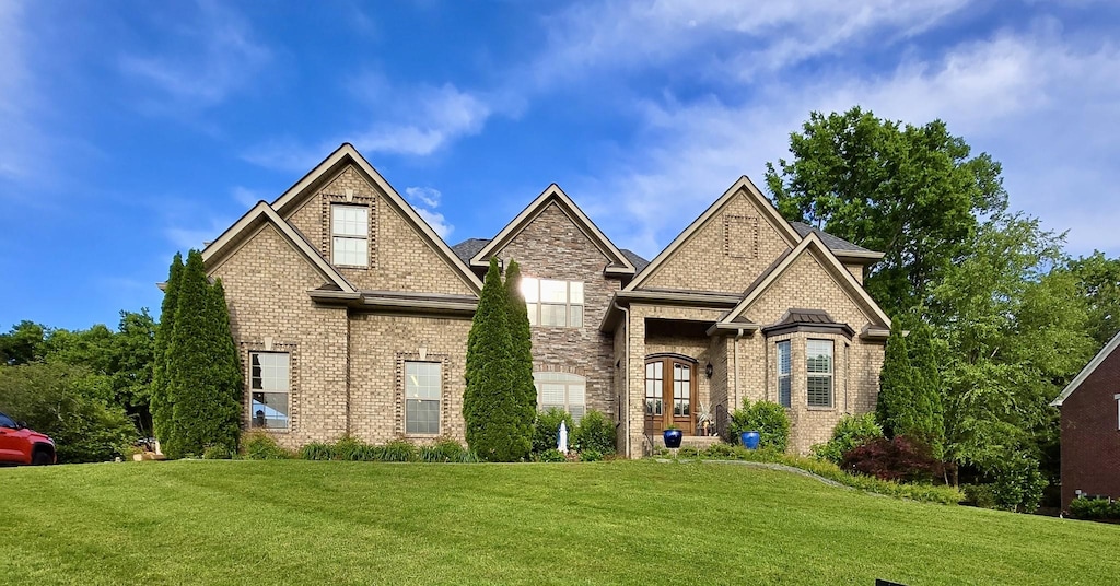 view of front of house with a front yard and brick siding