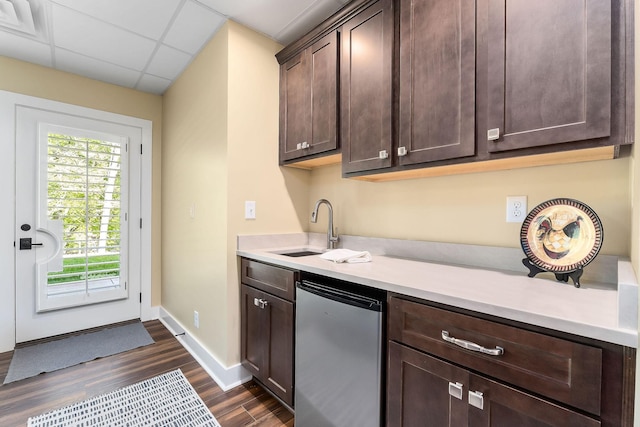 kitchen with dark brown cabinets, refrigerator, a sink, light countertops, and dark wood-style floors